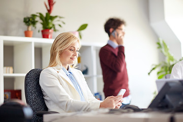 Image showing happy businesswoman with smartphones at office