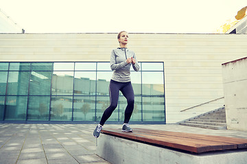 Image showing woman making step exercise on city street bench