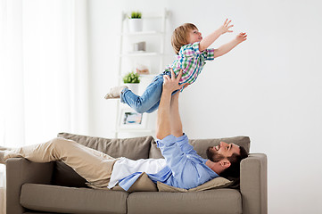 Image showing happy young father playing with little son at home