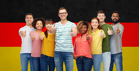 Image showing happy people showing thumbs up over german flag