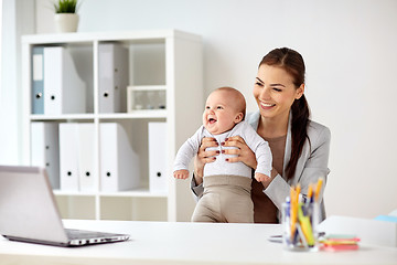 Image showing happy businesswoman with baby working at office