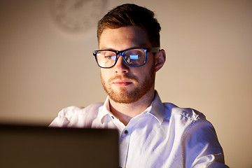 Image showing businessman in glasses with laptop at night office