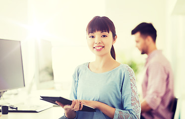 Image showing happy creative female office worker with tablet pc