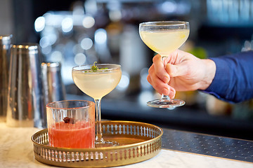 Image showing bartender with glasses of cocktails at bar