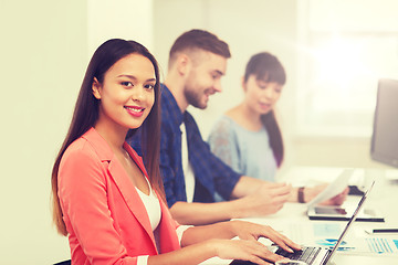 Image showing happy african woman over creative team at office