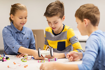 Image showing happy children building robots at robotics school