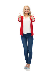 Image showing happy smiling young woman showing thumbs up