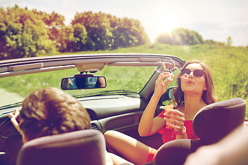 Image showing friends driving in car and blowing bubbles