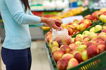 Image showing woman with bag buying apples at grocery store