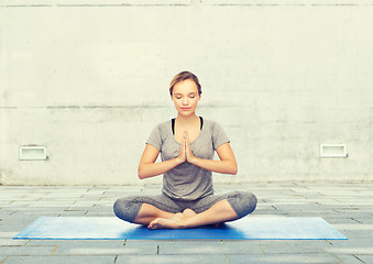 Image showing woman making yoga meditation in lotus pose on mat