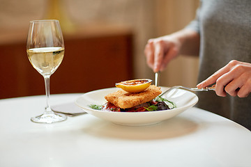 Image showing woman eating fish salad at cafe or restaurant