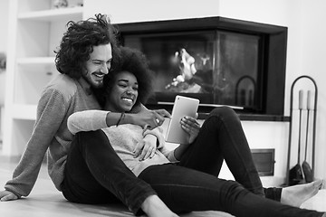 Image showing multiethnic couple used tablet computer on the floor