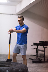 Image showing man workout with hammer and tractor tire