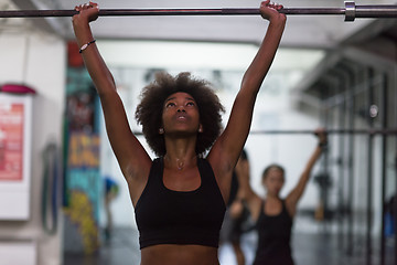 Image showing black woman lifting empty bar