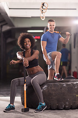 Image showing multiethnic couple after workout with hammer