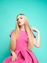 Image showing The beautiful young woman in pink mini dress posing at studio