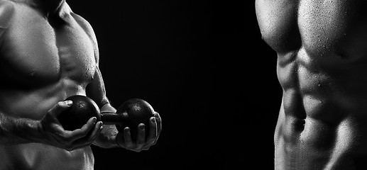 Image showing The torso of attractive male body builder on black background.