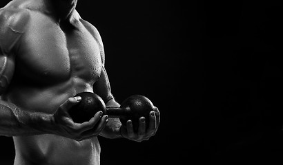 Image showing The torso of attractive male body builder on black background.