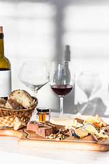 Image showing Wine, baguette and cheese on wooden background