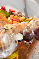 Image showing Wine, baguette and cheese on wooden background