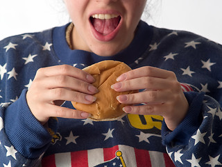 Image showing Lady eats hamburger