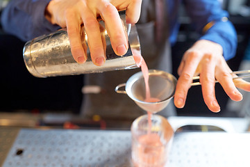 Image showing barman with shaker preparing cocktail at bar