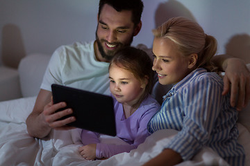 Image showing happy family with tablet pc in bed at home