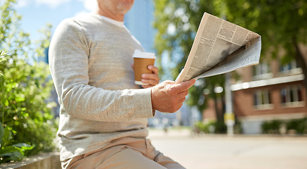 Image showing senior man with coffee reading newspaper outdoors