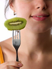 Image showing Beautiful lady eats kiwi