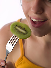 Image showing Teen eats kiwi