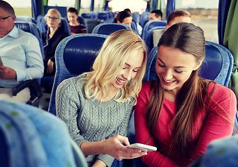 Image showing happy young women in travel bus with smartphone