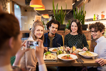 Image showing friends with smartphone fotographing at restaurant