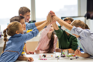 Image showing happy children making high five at robotics school