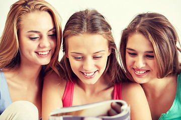 Image showing friends or teen girls reading magazine at home