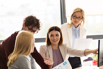 Image showing happy creative team with computer in office