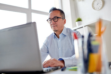 Image showing businessman in eyeglasses with laptop office