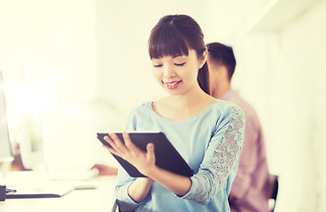 Image showing happy creative female office worker with tablet pc