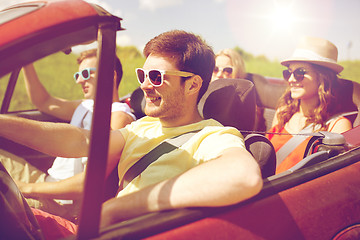 Image showing happy friends driving in cabriolet car