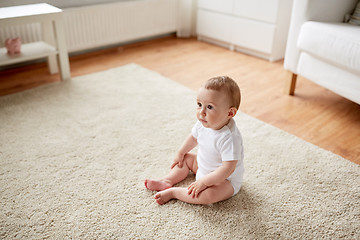 Image showing happy baby boy or girl sitting on floor at home