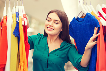 Image showing happy woman choosing clothes at home wardrobe