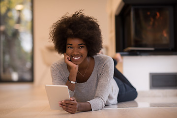 Image showing black women using tablet computer on the floor