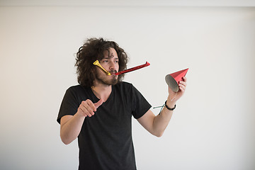 Image showing Portrait of a man in party hat blowing in whistle