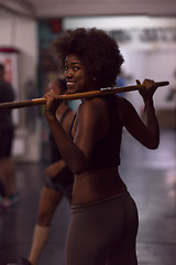 Image showing black woman lifting empty bar