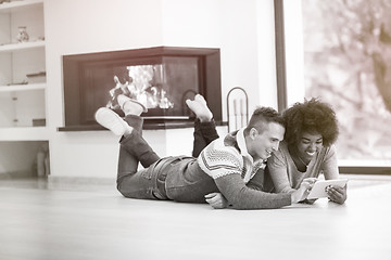 Image showing multiethnic couple used tablet computer on the floor