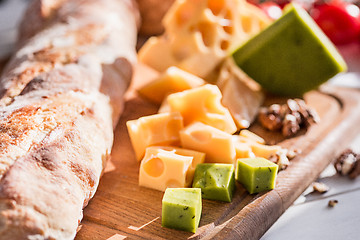 Image showing The baguette and cheese on wooden background