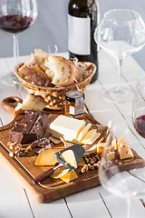 Image showing Wine, baguette and cheese on wooden background