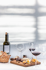 Image showing Wine, baguette and cheese on wooden background