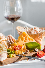 Image showing Wine, baguette and cheese on wooden background