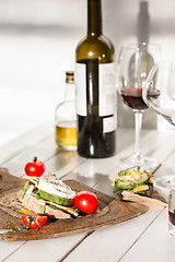 Image showing Wine, baguette and cheese on wooden background