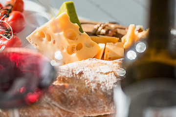 Image showing Wine, baguette and cheese on wooden background